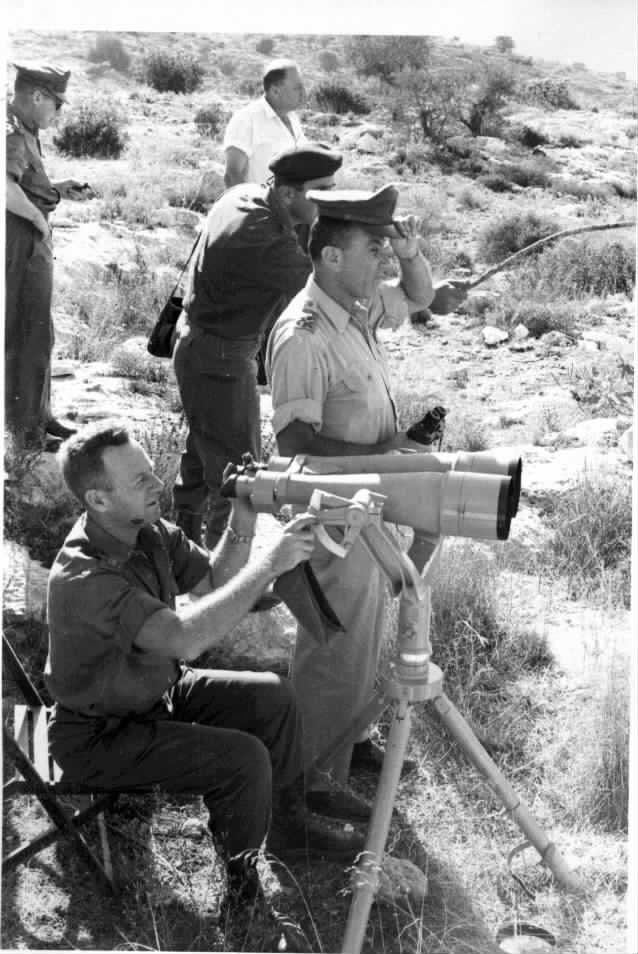 1960- בתמונה אנו רואים את ראש אמ"ן מאיר עמית ואת סגן אלוף סיסי צופה במשקפת טלסקופית. משמאל ומאחור- אל"מ אהרון יריב, אז מפקד חטיבת גולני.